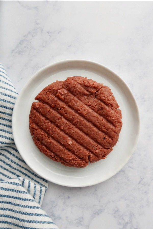 Ground protein patty on a plate.