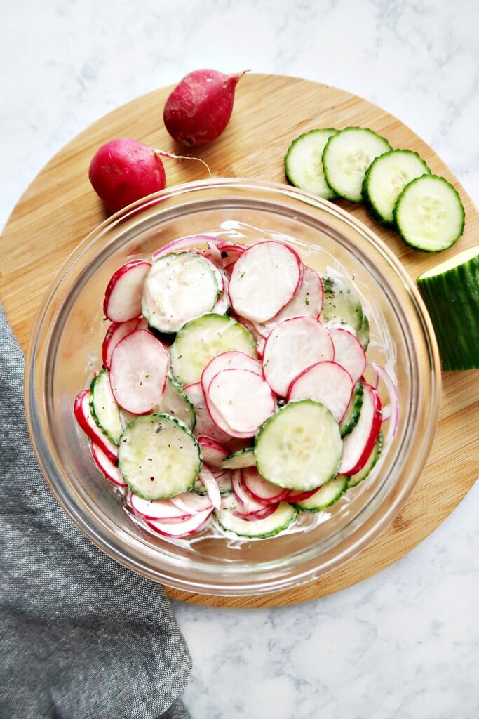 Sliced radishes with dressing in a bowl.