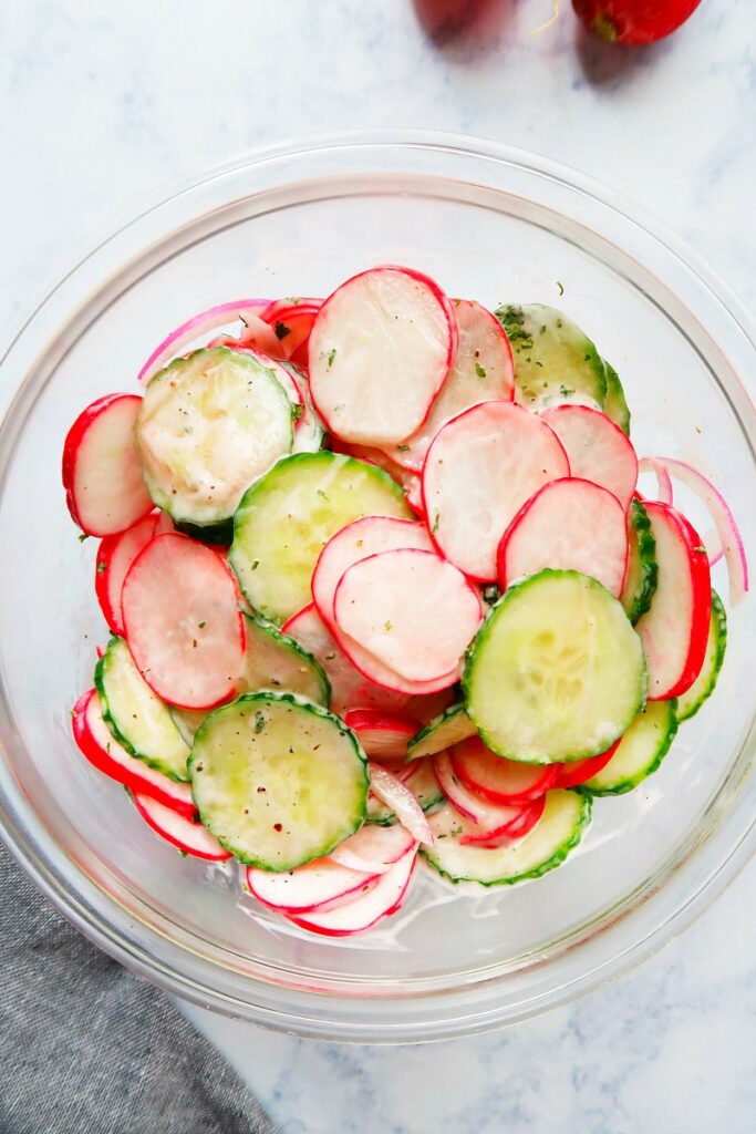 Creamy salad with radishes in a bowl.