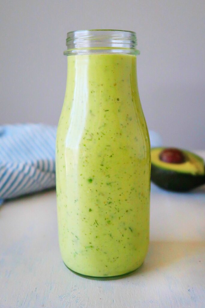 Avocado salad dressing in a tall glass.