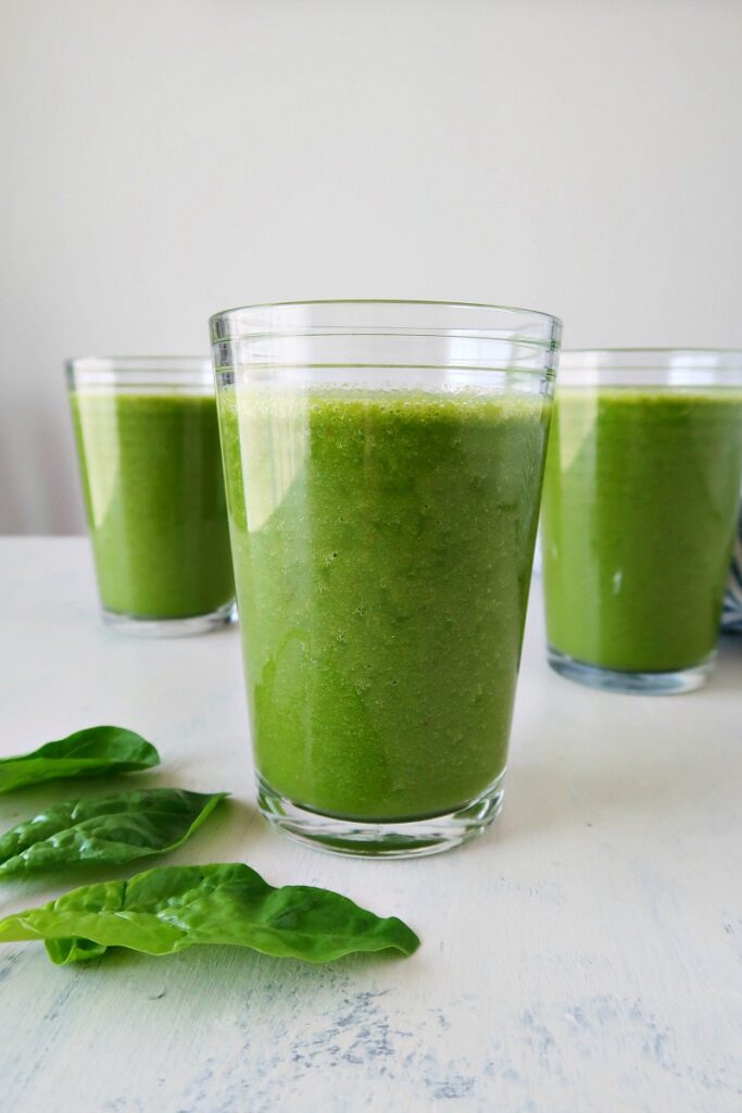 Vegan smoothie on a board with spinach.