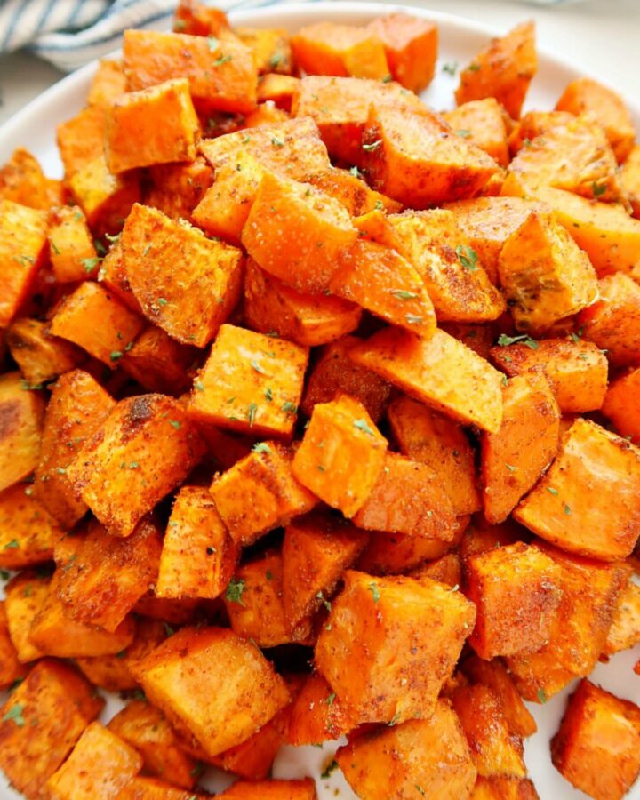 Plate of roasted sweet potatoes on a board.